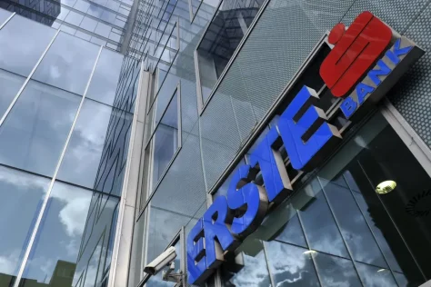 Стеклянный фасад офисного здания с синим логотипом и надписью Erste Bank.