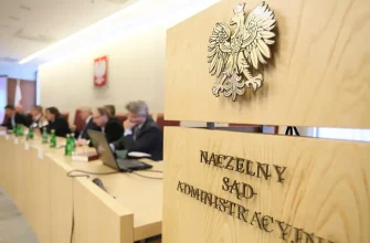 Герб Польши и надпись Высший административный суд на деревянной трибуне в зале.