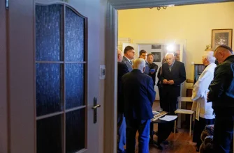 Доктор Тадеуш Боровский-Бешта (пожилой мужчина в черном костюме) общается с гостями и журналистами в помещении во время открытия новой штаб-квартиры Фонда "Wytchnienie" (Передышка) на ul. Świętojańska в Белостоке.